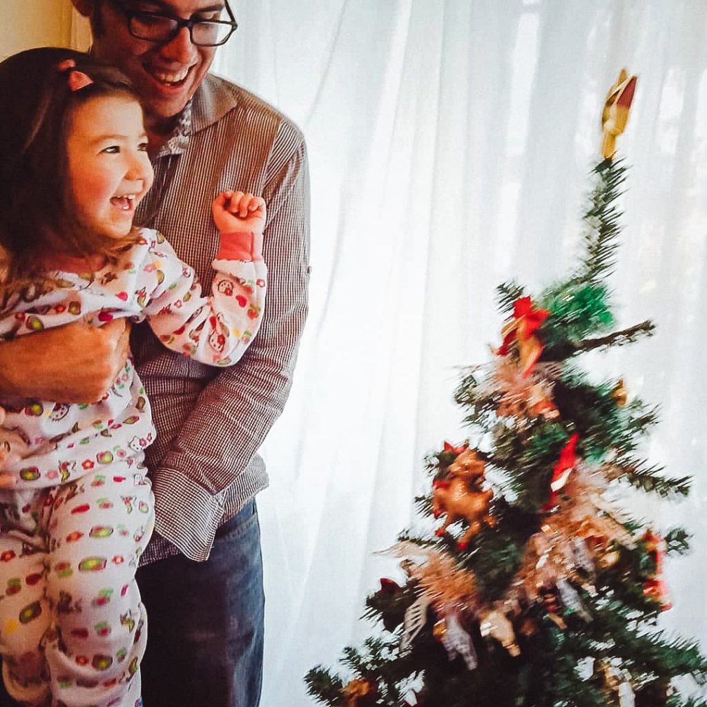 Father and daughter decorating the Christmas tree.