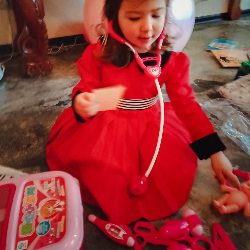 Girl playing with the doctor set she got for Christmas.