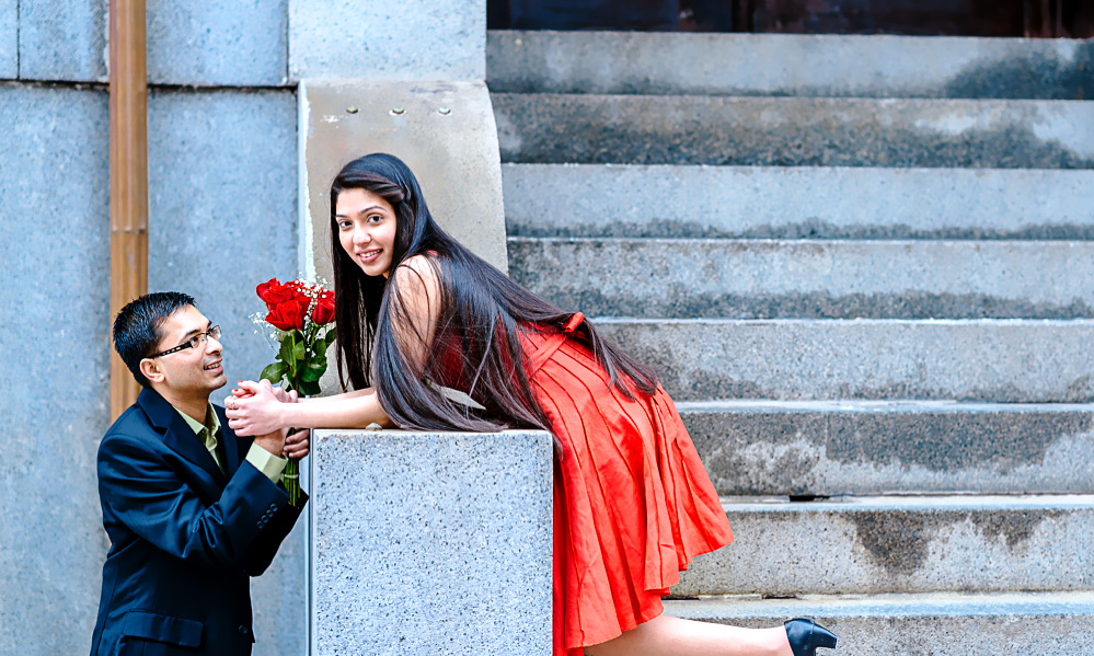 A man offers flowers to his fiance in this engagement photo from Boston Massachusetts