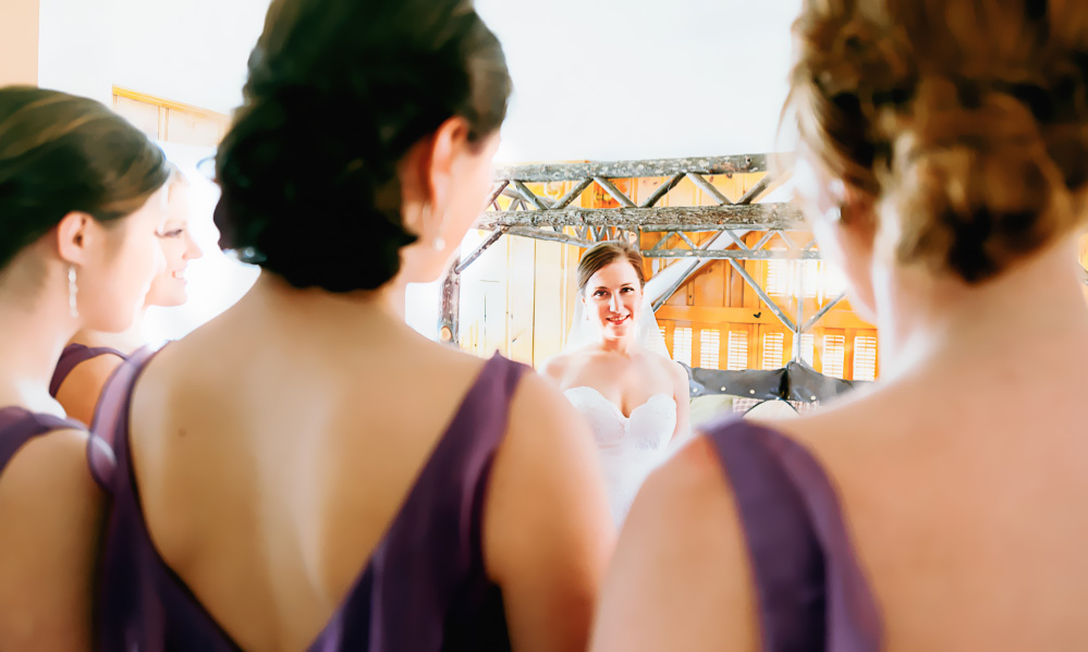 Bridesmaids admire the bride before her wedding after she finishes getting ready