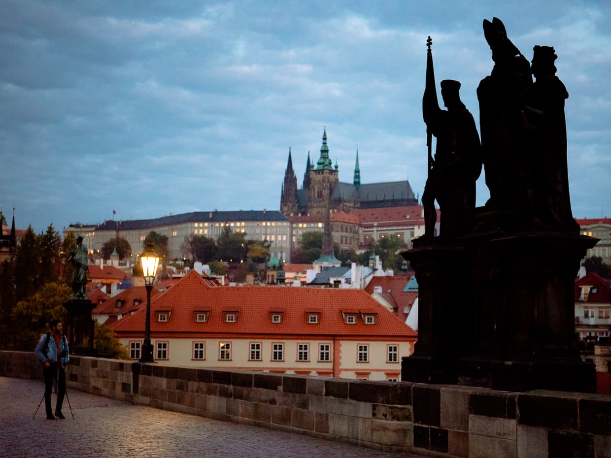 A statue on the Charles bridge with Prague castle in the background.