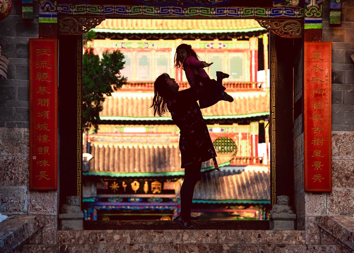 Playing in the gate in front of Wangu Tower in Lijiang.