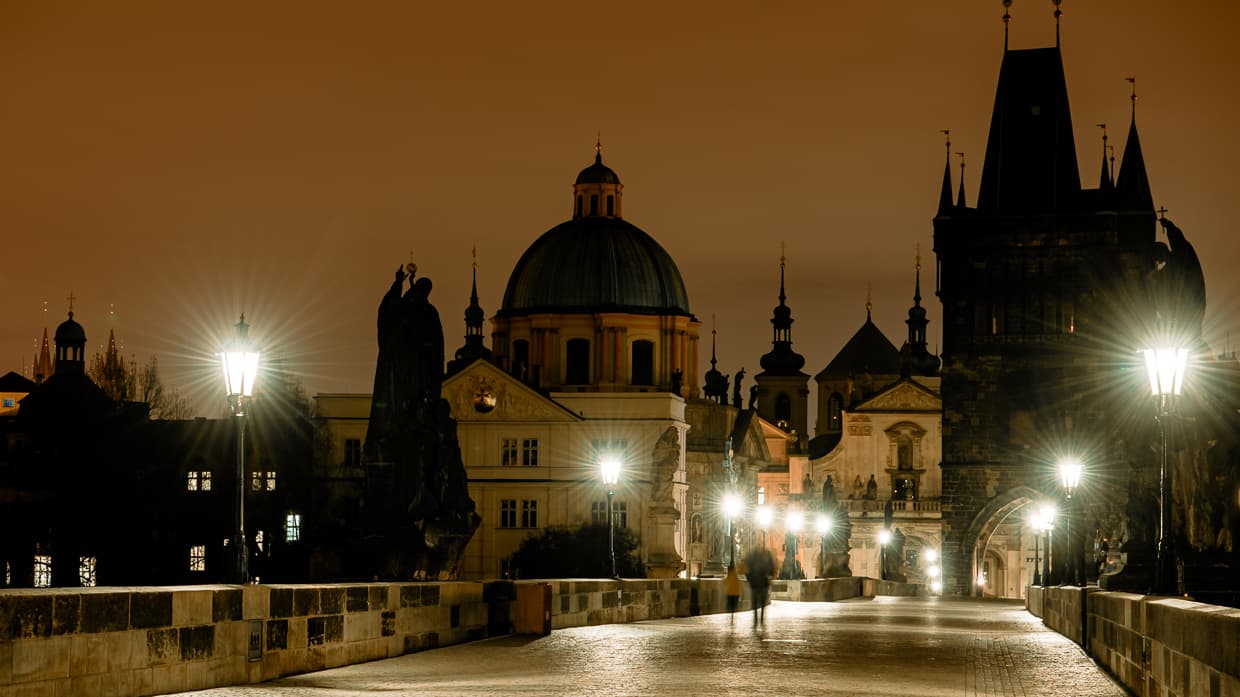 Prague's Charles Bridge at night with lamp light.