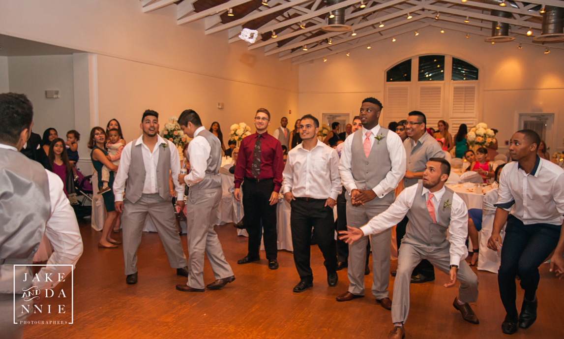 Single guys at the wedding reception try to catch the garter.