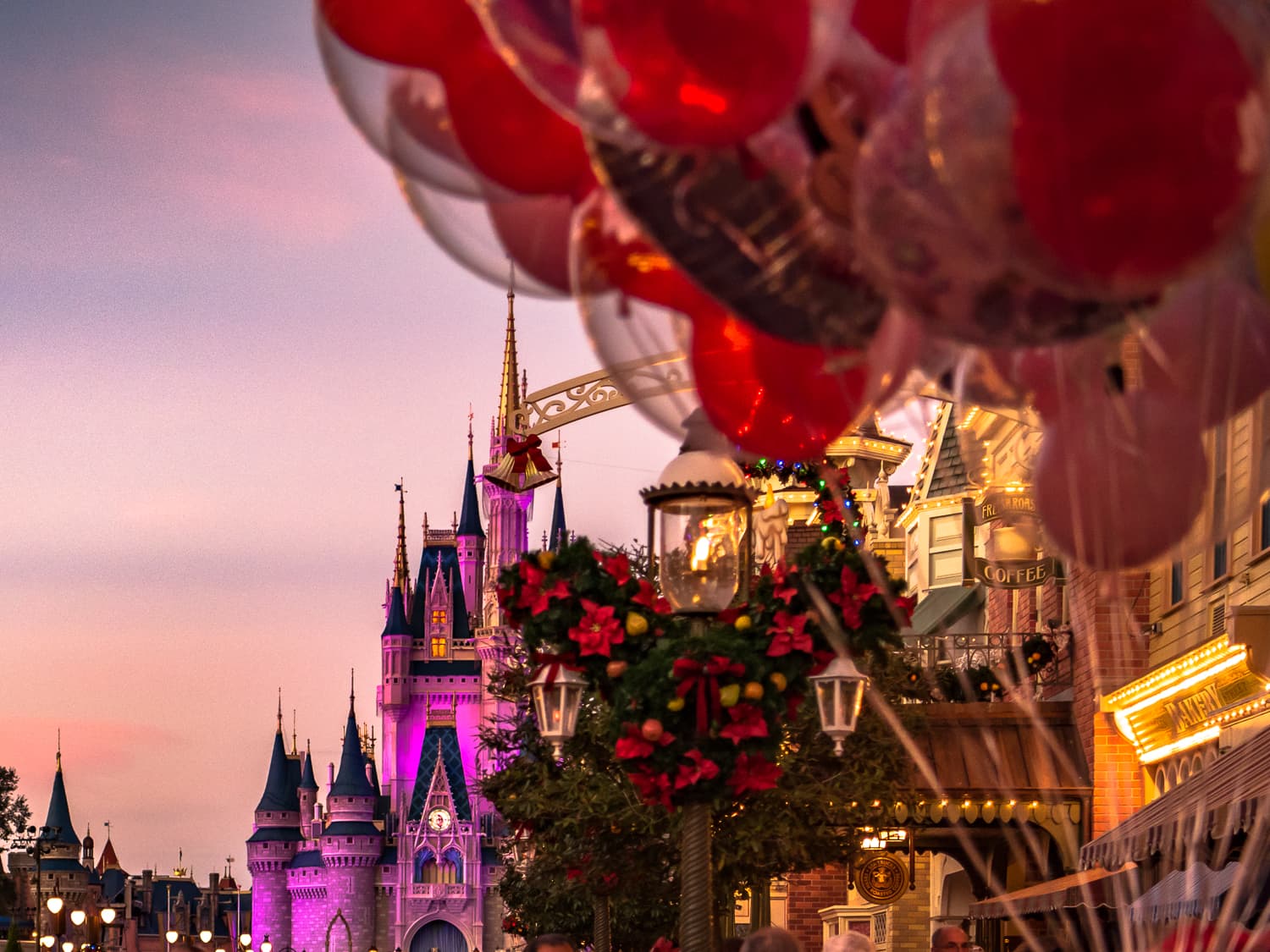 Ballons and Christmas decorations in front of the cinderella castle at magic kingdom.