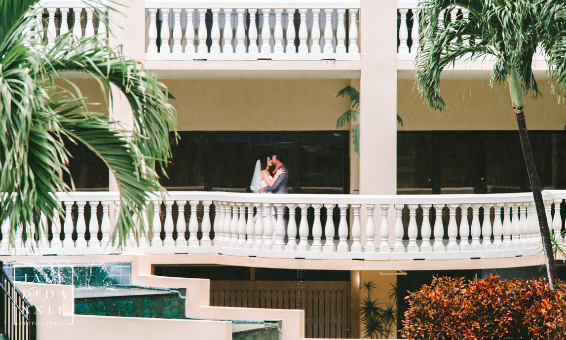 The bride and groom kiss on balcony at the Sirata Beach Resort in St. Petersburg, Florida
