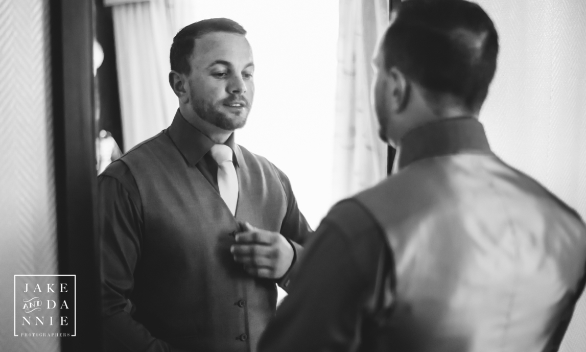 Florida Groom checking himself out in the mirror as he fixes his vest.