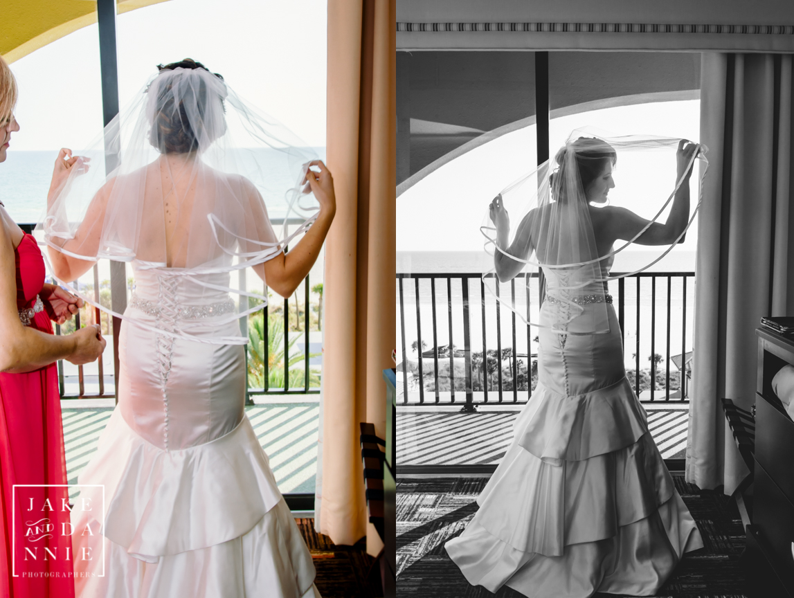 The bride readies her veil with the ocean in the background in Florida