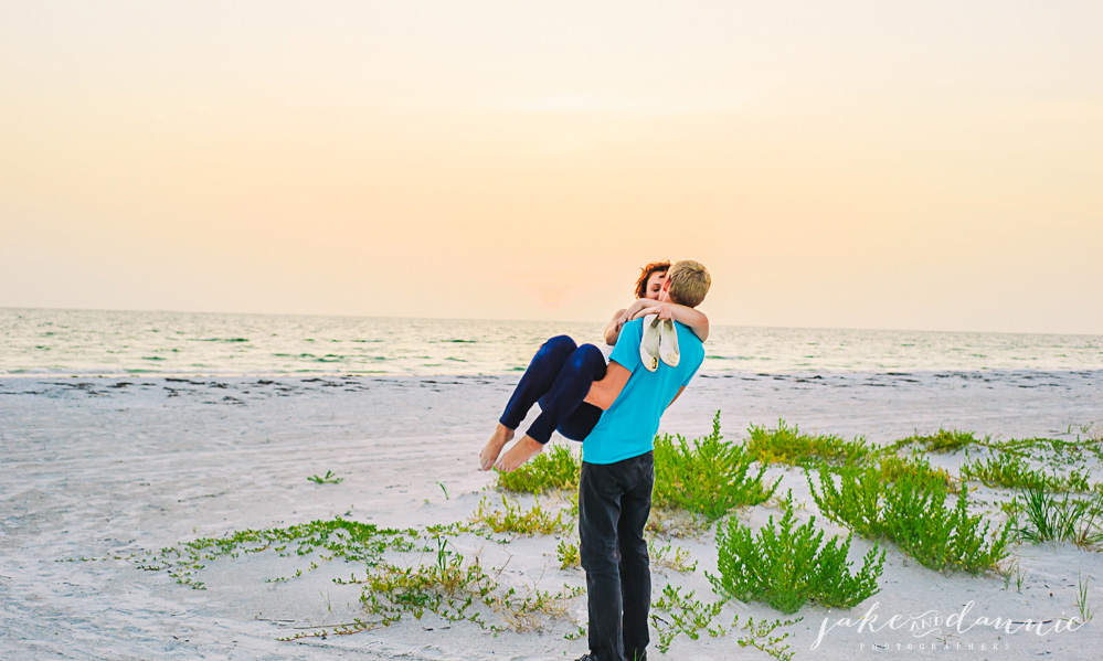 A romantic photograph of Trevor holding Susie as the sun goes down in Florida