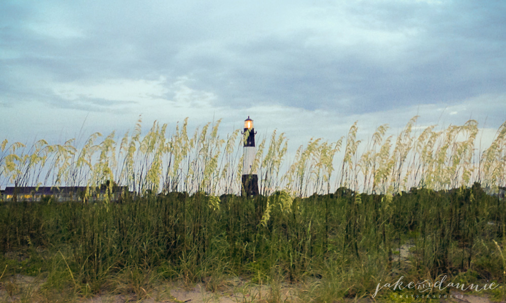 A lighthouse on Tybee Island as the sun begins to set behind the photographer