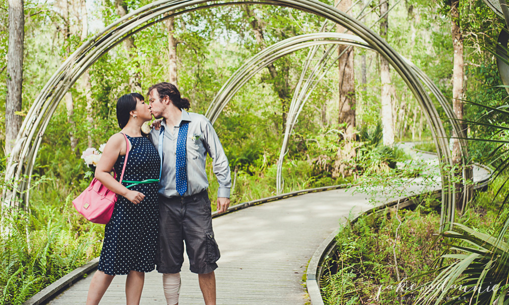 Attractive young couple kissing on a boardwalk in the park