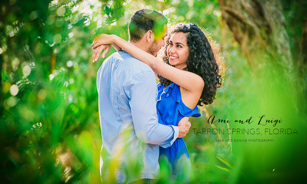 Couple hold each other wearing blue in the forest during their engagement session in Tarpon Springs Florida