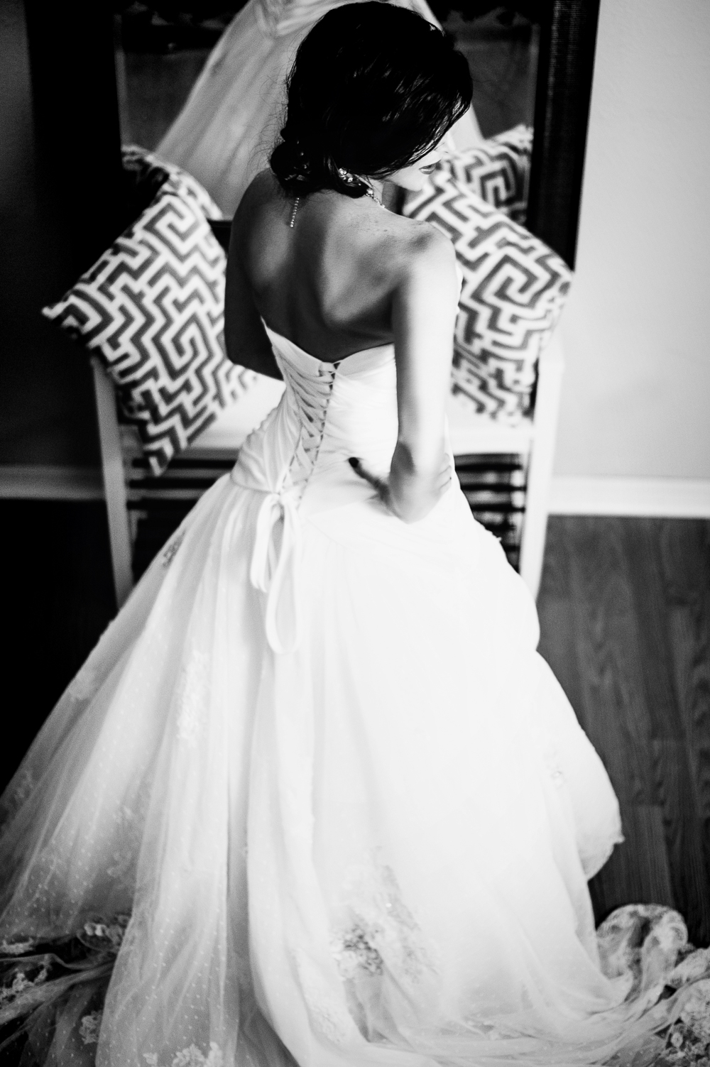 A bride turns away from the mirror and looks over her shoulder