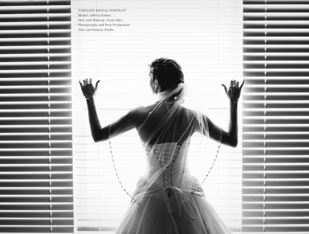 A bride looks out the window wearing her wedding dress.