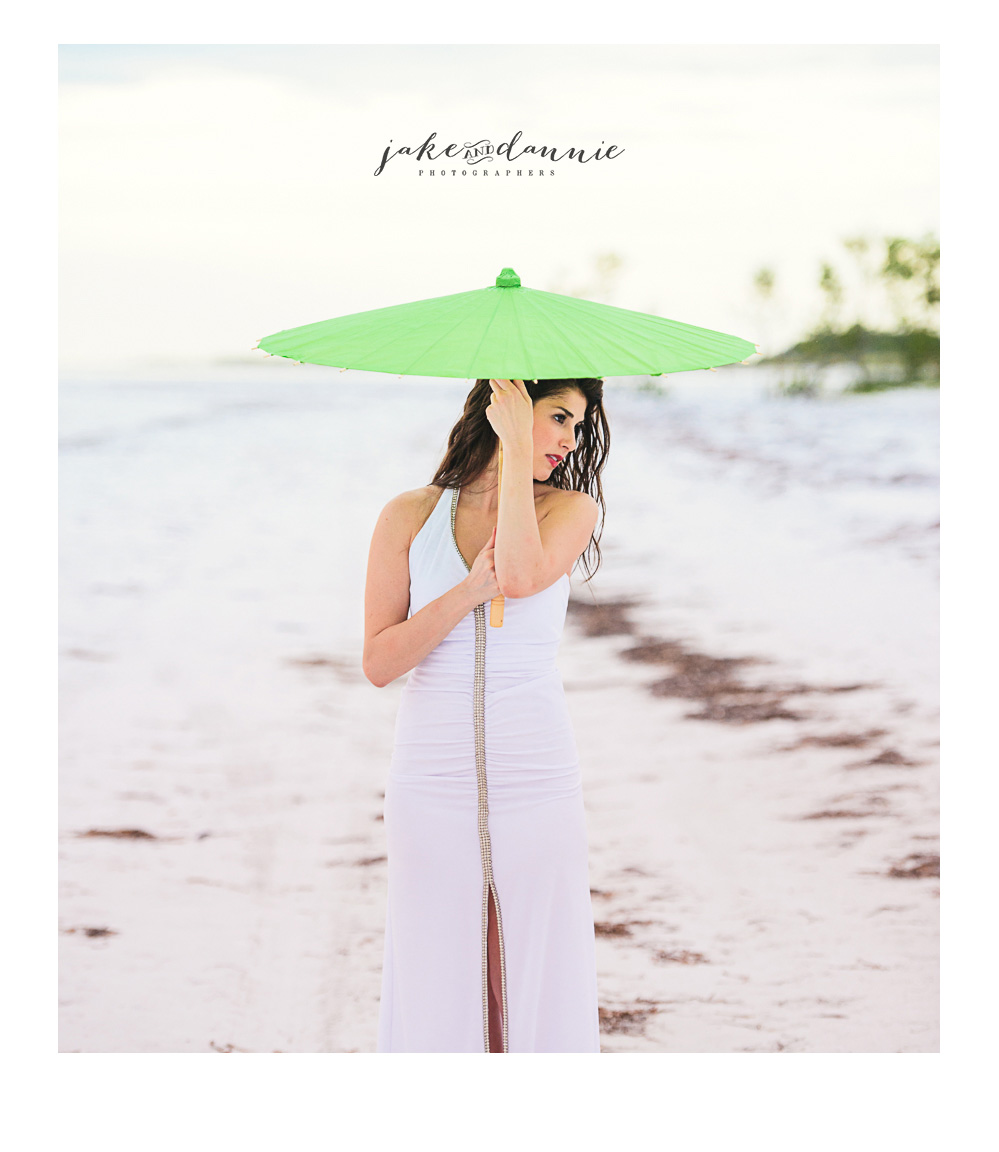 Allison shades herself under green umbrella near the ocean