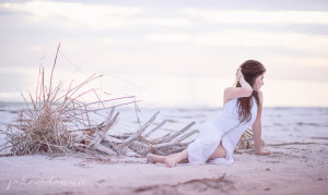 model lies in sand at fort desoto in florida