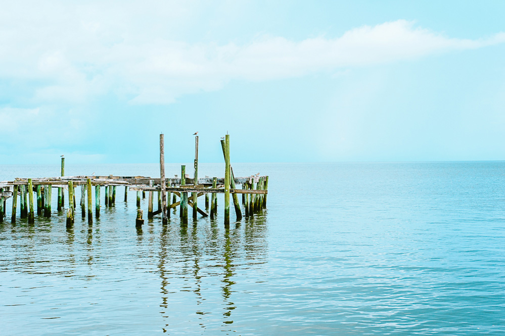 A dock in Cedar Key, Florida with clouds over the water