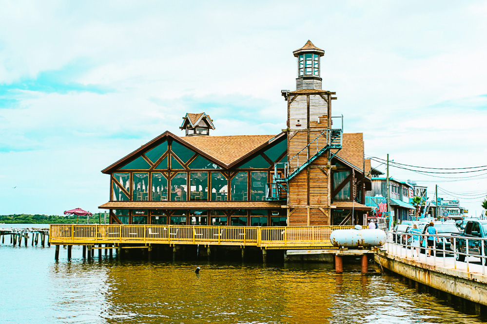 A building on the waterfront with a lighthouse. Nice reflection.