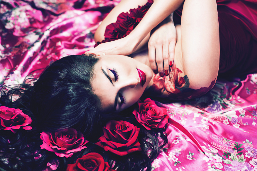 Model relaxes on pink kimono with flowers in her hair