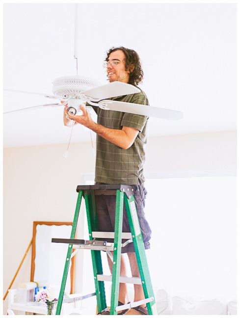 Jake taking down the ceiling fan in our living room to improve the lighting in our photography studio