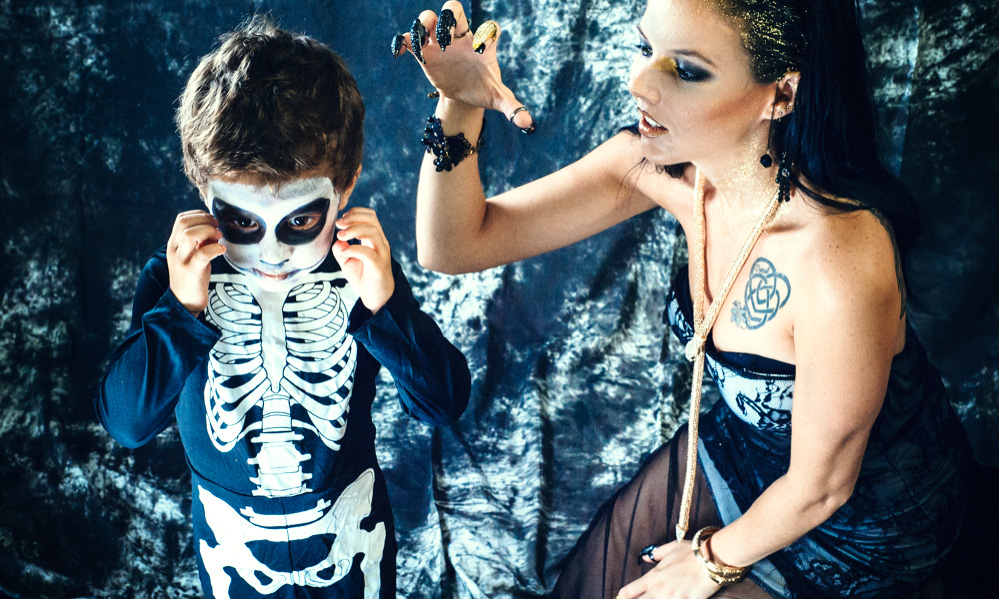 Cute and spooky halloween costumes. Mother and son as sorceress and skeleton