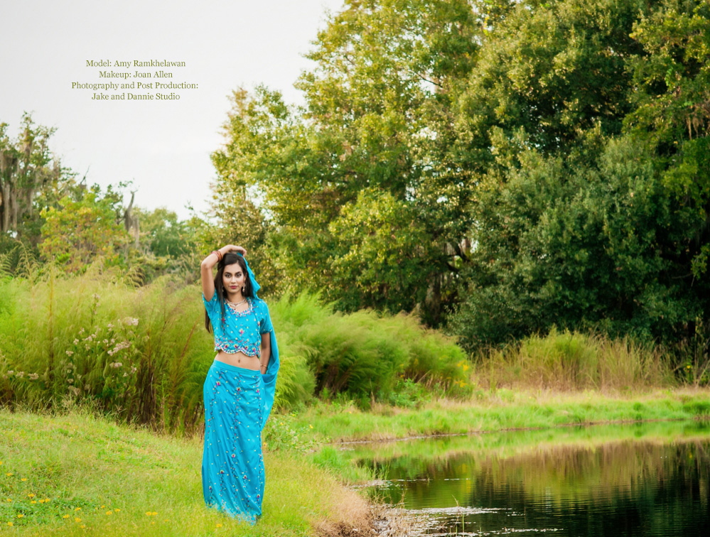 Beautiful woman in Indian clothing stands by a pond